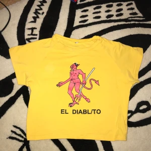 Gul croptop med en djvulsgrabb på  - Gul tröja med tryck. Aldrig använd. Köparen betalar frakt! Tar Swish 