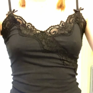 Svart topp spets  - Ursäkta min dåliga kamera) Jättefin topp i svart med spets och rosetter som tyvvär inte kommer till användning! Den är köpt här på plick men är inte sliten  även om den är använd!  Den sista bilden är på spetskanten  längst ned på tröjan den är en strl s men passar Ming både mindre och större:) frakt tillkommer på 11 kr men vid snabbt köp kan jag betala för den<3 det var flera intresserade så vi kör budgivning, skriv till mig om ni vill buda!!💕💕 budgivningen avslutas nu om 1 timme (18:00) så att ni vet!