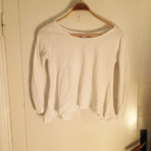  - Utsvängd långärmad tröja, litet hål i vänstra hörnet (se bild). Kort i storleken