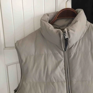  - Beige dunväst perfekt till våren. Storlek M. Inga hål eller fläckar, jättebra skick!