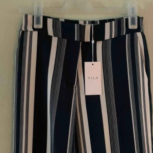 Randiga kostymbyxor  - Helt oanvända vida byxor från vila. Prislapp kvar. Frakt ingår i priset, spårbart. 