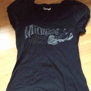  - Sparsamt använd topp med print. Stl L. Stor bonus för de 2 charmsen som hänger längst ner på toppen (se bild 3). Frakt: 42 kr