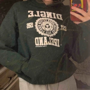  - Mörkgrön hoodie med vitt tryck. Mycket bra skick. Motivet föreställer en fyrklöver och text. 