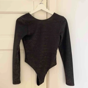  - Helt oanvänd body med glitter på och öppen rygg! Superfin! 