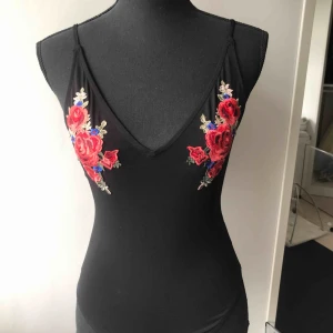  - Svart body med broderade blommor. I mycket gott skick! Köparen står för frakten 🌹