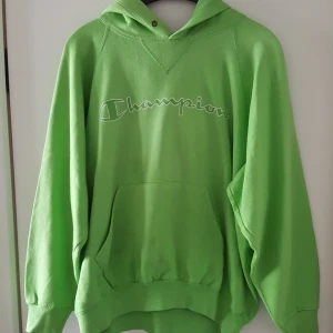  - Vintage grön Champion tröja, är typ limegrön. Den är inte i perfekt skick, har två igensydda hål, ett nedtill på ena ärmen och ett uppe vid axel baktill samt har en del fläckar, främst nere på ärmarna men även någon framtill m.m (se bild 2). Tycker dock fläckarna är rätt svaga och inte syns så mycket, de kanske kan gå bort i tvätten.