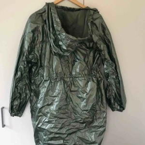  - Asball regnjacka från Visual Clothing Project. I metallaktig ljusgrön. Tunn. Går att justera passform. I superbra skick. Storlek S. Köparen står för frakten. 