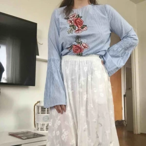  - 🌼 Superfin randig blus med rosapplikationer. Smock och utsvängd i ärmen. Sparsamt använd. Vid frakt tillkommer 60kr 🌼
