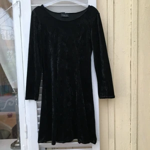 Svart sammetsklänning retro  - En superfin svart klänning i sammet. Går in lite k midjan och ger en jättefin silhuett. Långärmad och slutar strax ovanför knäna. I utmärkt skick! St 38!
