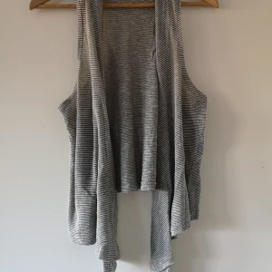 Randig over size väst.  - Randig over size väst i grått från FOREVER 21. Lång fram, kort bak.