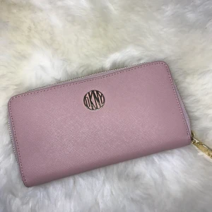 DKNY plånbok - DKNY plånbok med korthållare och fack för mynt och kontanter. Köptes för 1400 men säljer för 600, kan sälja för 500 vid snabbt köp. Kan mötas i hela Stockholmsområdet.