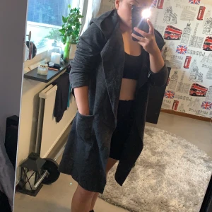 Kappa från Nelly - Svart/grå kappa från Nelly. Aldrig använd på grund av att den blev för stor.