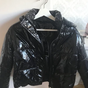 Glansig jacka ifrån Boohoo🥰 - Säljer denna jättesnygga jacka då den är för kort för mig på ärmarna, och jag är 173 cm. Den är helt ny och oanvänd så därmed finns prislapp! Jackan har även en avtagbar luva!