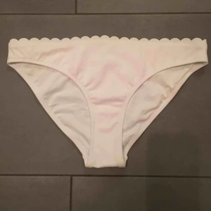 Bikiniunderdel xs - Vit bikiniunderdel med detalj upptill. Aldrig använd p.g.a storlek. Stl. xs men passar nog även s. Säljer även svart likadan