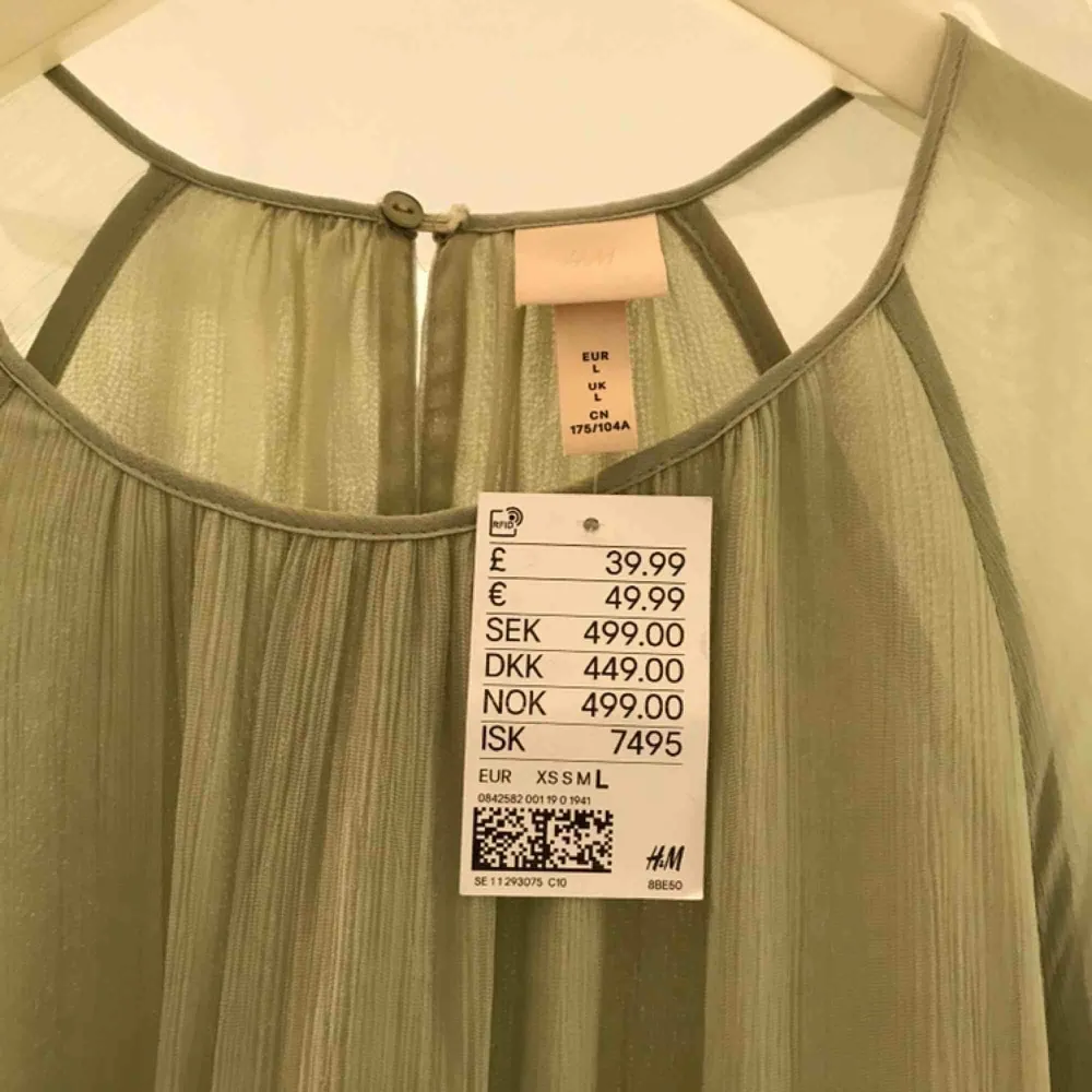 Ny klänning från H&M Trend. Storlek L. Fin mintgrön färg och fina detaljer på ärm och mitt på klänningen. . Klänningar.