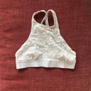 Urban outfitters bralette - En till bralette från Urban outfitters! Väldigt fin vit spets och går högt upp, perfekt under en tröja med liknande form. Inte särskilt använd så i bra skick, säljer för 100kr eller 150kr för både denna och braletten i förra annonsen. Frakt är 44kr🥰