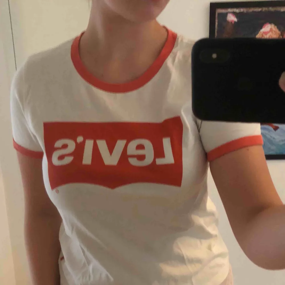 Krämvit t-shirt från Levi’s i storlek M, orange logga. Frakt på 42kr tillkommer🥰. T-shirts.