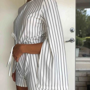  - Superfin playsuit i randigt, fina detaljer som slits i ärmen och mer öppen i rygg! Även knytenas i midja som går att reglera. 