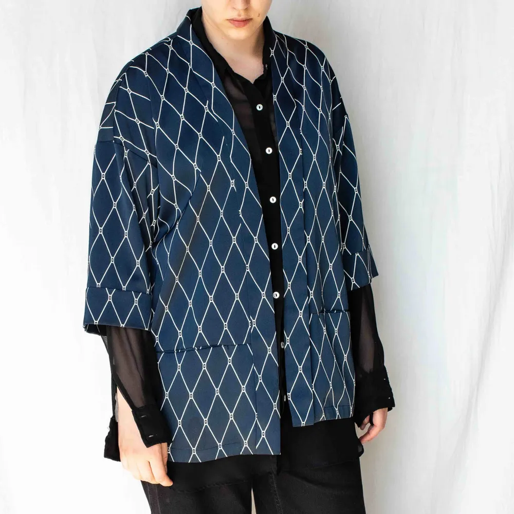 Tunn kimonojacka med fickor. Mörkblå mönstrad viskossatin. Skön på och faller snyggt. Hämtas i Stockholm annars tillkommer frakt.. Blusar.