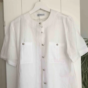  - Vit skjorta/blus med silvriga knappar. Väldigt snygg och knappt använd då det inte riktigt var min stil. Storlek 38
