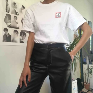  - Svarta byxor i läderimitation med vit kontrastsöm från Zara. Lite utsvängda ner mot vaderna Märkta som XS men är lite stora i storleken.  Endast använda en gång!! 