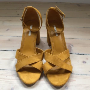 Sandalett - Fin, oanvänd sandalett med bredare klack från pull&bear i mörk senapsgul färg. Kan skickas också men då tillkommer fraktkostnad.