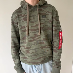 Alpha industries hoodie   - Säljer denna camouflage färgade ALPHA INDUSTRIES hoodie i storlek S. Fint skick, den röda tagen är dock lite skadad, se bild. Spårbar frakt tillkommer på 63 kr