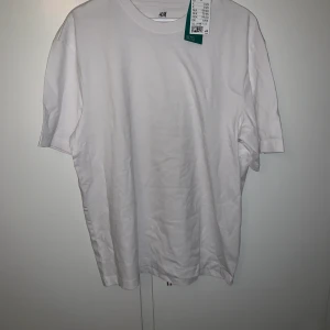Vit t-shirt från HM Strl M - Oanvänd tisha från hm i ett lite tjockare material. Oversized M herr.