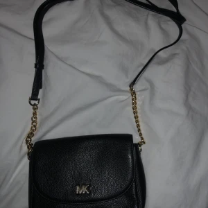 Michael Kors Väska - Svart Michael Kors väska med guld detaljer. Älskar denna!! Men fick en ny väska så har slutat använda den. Det går att ändra längden på axelbandet. Verkligen jättebra skick.