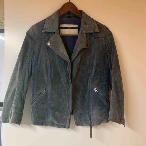  - Tre kvarts ärmad jacka i silverblå äkta mocka. Kemtvättad. 