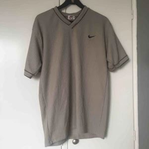  - En oversized Nike T-shirt i grå/grön färg. 