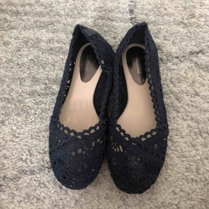  - Ett par mörkblå ballerinaskor i stickat material