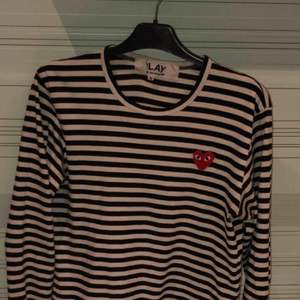 CDG PLAY longsleeve i svart. Köpt på dover street market i London. Kvitto medkommer vid köp. Condition är 8/10 men inga märkbara flaws då den endast är vanligt buren ett antal gånger. Nypris var 1300kr. Meetup i Stockholm