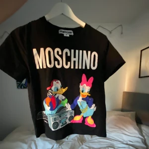 HmXMoschino tshirt  - Säljer denna tshirt från HmXMoschino i strl S🥰 köpt av en på plick men aldrig använt, super bra skick😍150kr + frakt💗 köpt för 300kr