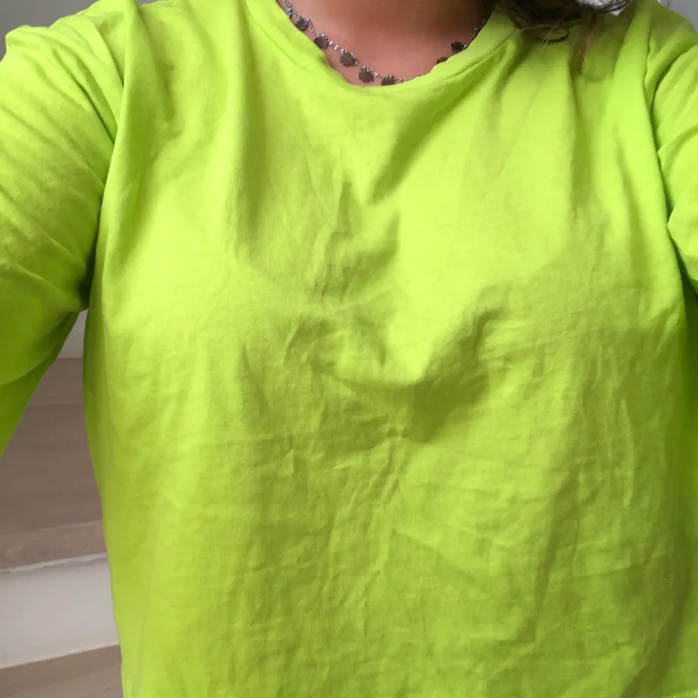 Säljer denna neongröna t-shirten från monki då jag endas sköpte den till en temafest! Tröjan är croppad och är lite oversize i modellen💕  Endast använd en gång!. T-shirts.