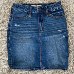 Tajt jeanskjol från Hollister - Säljer denna tajta jeanskjol från Hollister eftersom den nu är för liten för mig. Färgen är mörkblå med lite, lite slitningar på framsidan men fickor både fram och bak. Storlek 24 i midjan.