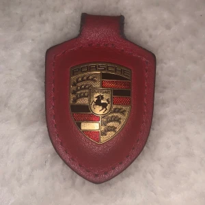 Äkta Porschenyckelring - Äkta Porschenyckelring i rött läder! 🥰 Följde med när vi köpte en bil, men själva ringen finns inte kvar :(: Begagnat skick men supercool ändå! 🌟