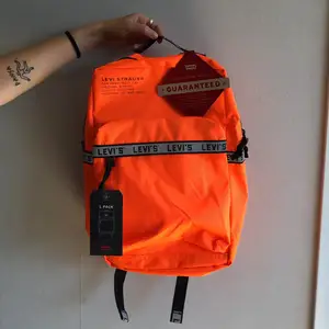 Oanvänd neon-orange backpack från Levis. 25L med laptopficka inuti.