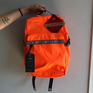 Ryggsäck Levis - Oanvänd neon-orange backpack från Levis. 25L med laptopficka inuti.