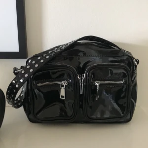 Noella lackväska - Säljer min iprincip oanvända noellaväska i svart lack. Använd ett fåtal gånger så perfekt skick, långt band medföljer. Köptes för 750kr