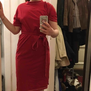  - Röd klänning med vita sömmar från Bershka. Knyts i midjan. Slits i sidan. Gott skick! Möts i innerstan/köparen står för frakt.