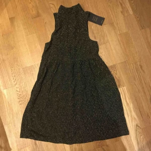  - Jättesnygg ”nyårs” klänning i guld med blixtlås bak. Stretchmaterial  Helt ny med prislapp kvar. Köpt utomlands på 