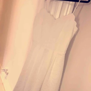 - Vit klänning från vila använd 1 gång. Säljes då den är liten i bysten för mig. Den markerar midjan fint och är inte för kort. Fina detaljer runt bysten och tunna band. 