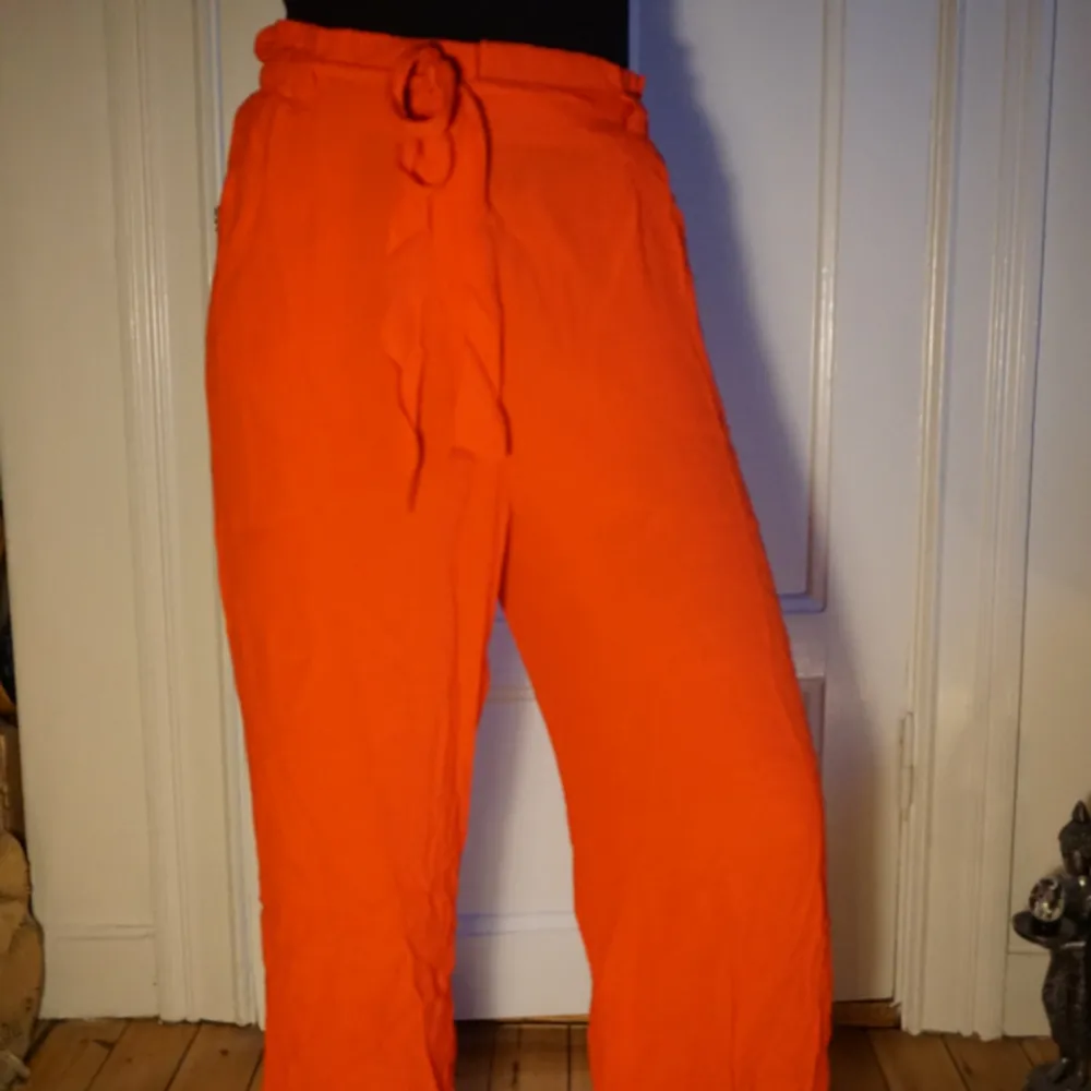 Härligt röd/orangea byxor! Mycket tunna och skönt somrigt tyg med ett snyggt skärp i samma tyg! . Jeans & Byxor.