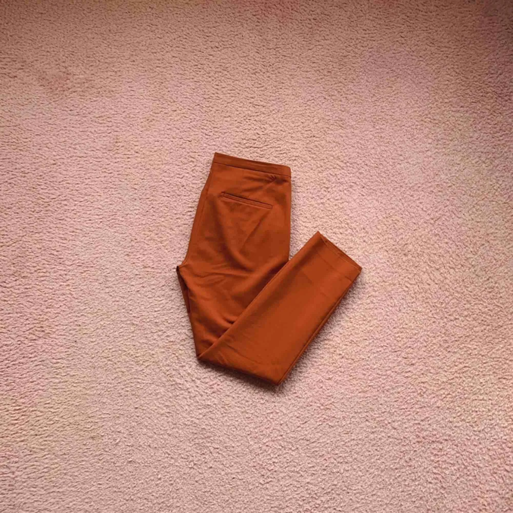 Low waist ankle kostymbyxor i en fin rost röd/orange färg. Väldigt fint nu i höst! De är använda, och i ok skick.. Jeans & Byxor.