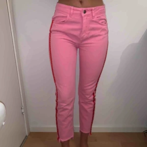  - Rosa jeans med röda streck längs sidan, raw hem