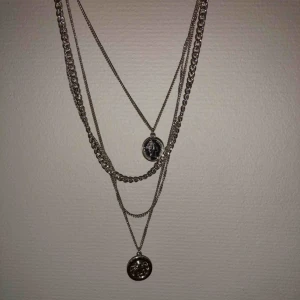  - Medellångt halsband med flera kedjor.