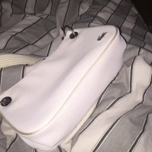  - Vit Lacoste väska,aldrig använd. 
Betalas med swish och köparen står för kostnad av frakt 