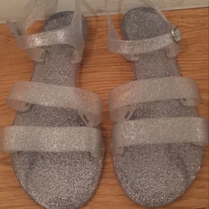  - Glittriga plastsandaler från juju.