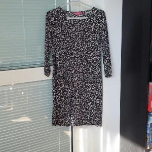  - Rak klänning från Indiska i blommigt mönster. Två fickor fram och trekvartsärmar, i mycket bra skick. Använd 1 gång. 